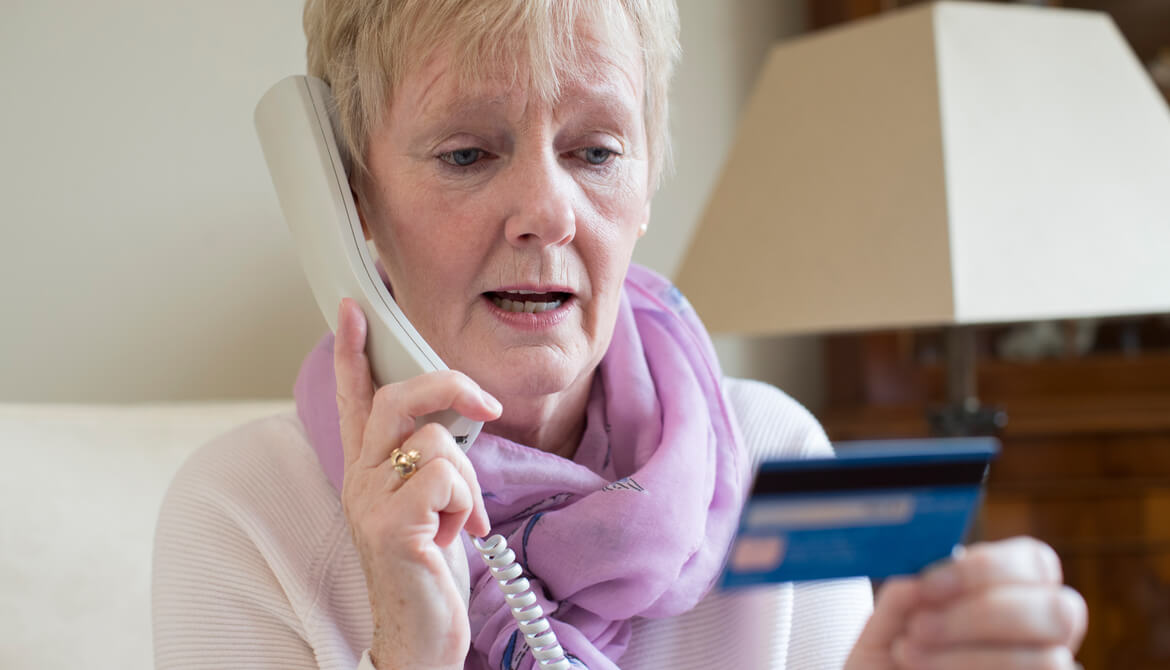 senior woman giving credit card information on phone