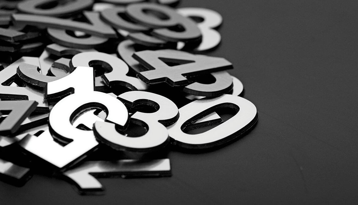 jumbled pile of shiny metal numbers on a black surface