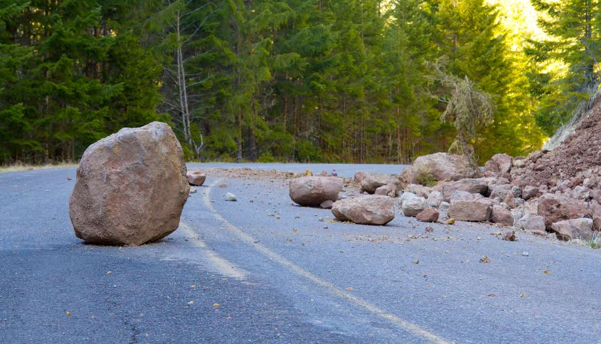 boulder and rock slide debris in the road