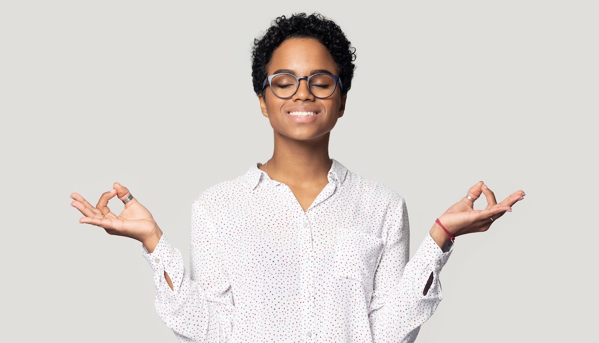 calm young Black businesswoman meditating to reduce stress