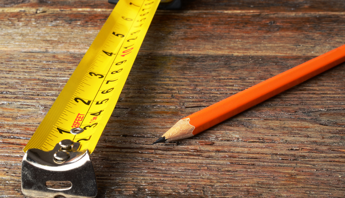 yellow tape measure and orange wooden pencil