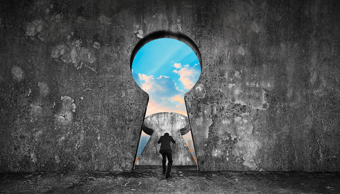 businessman pushing open a giant keyhole in a stone wall to reveal blue sky