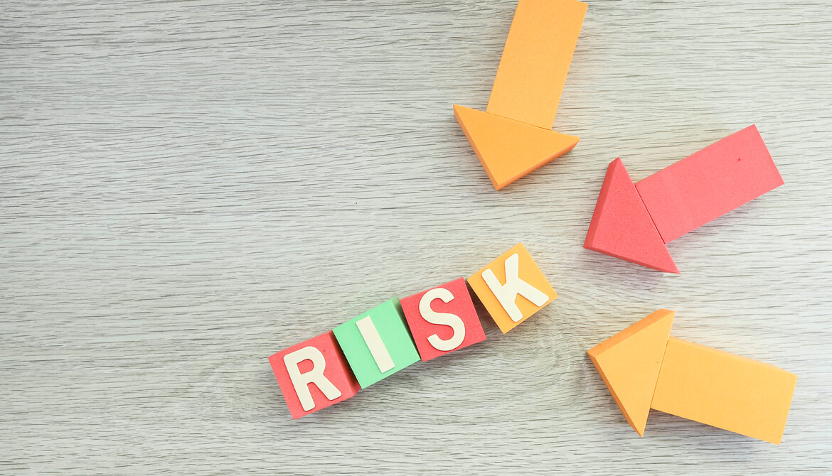 wooden blocks spelling out the word risk with wooden arrows pointing to them