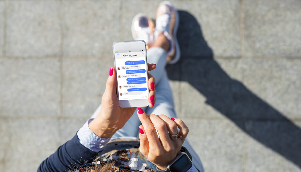 overhead view of a woman using a chat or instant messaging app on her smartphone