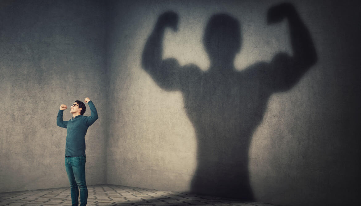 confident man flexing muscles in his shadow