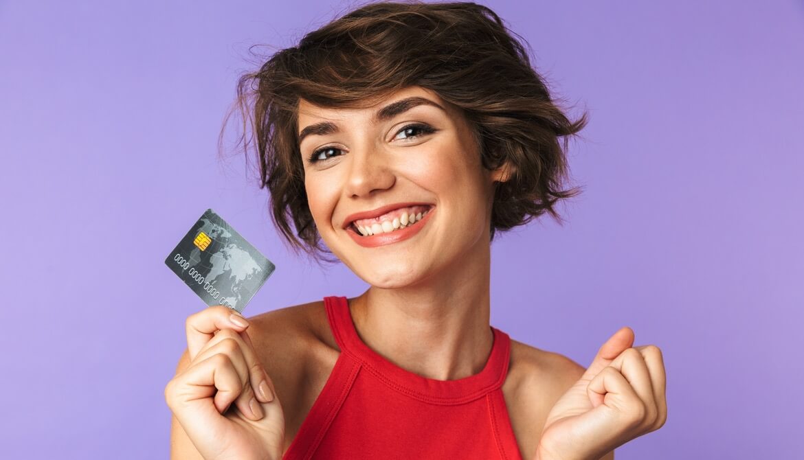 happy smiling young woman in red shirt holding credit card