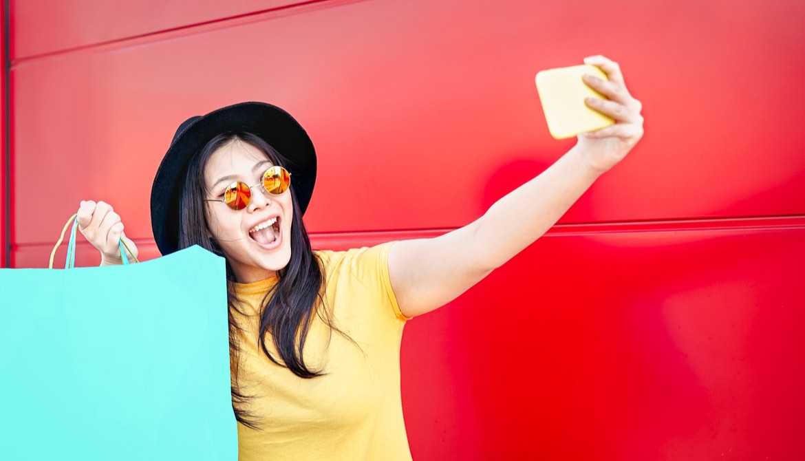 young asian woman taking selfie with shopping bags