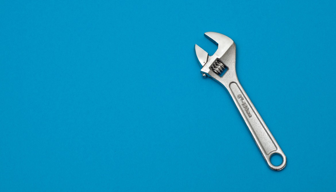 silver wrench on blue background 
