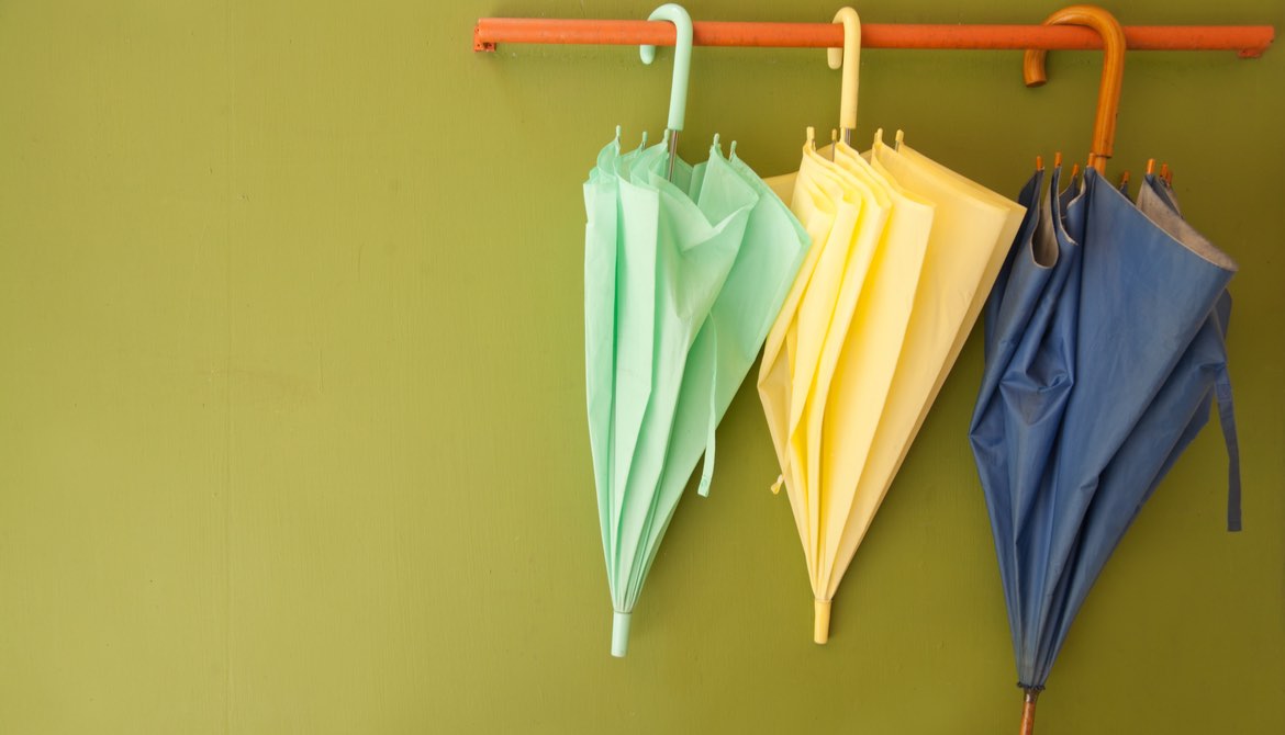 three umbrellas hanging on a bar