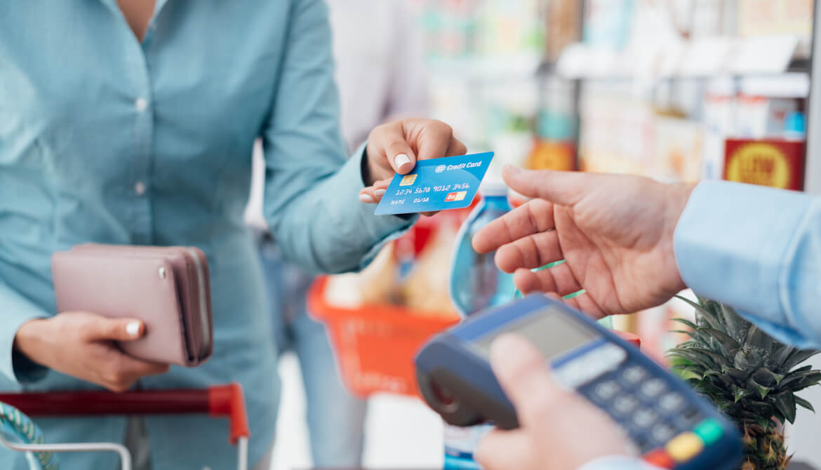 woman uses her credit card to check out at the grocery store