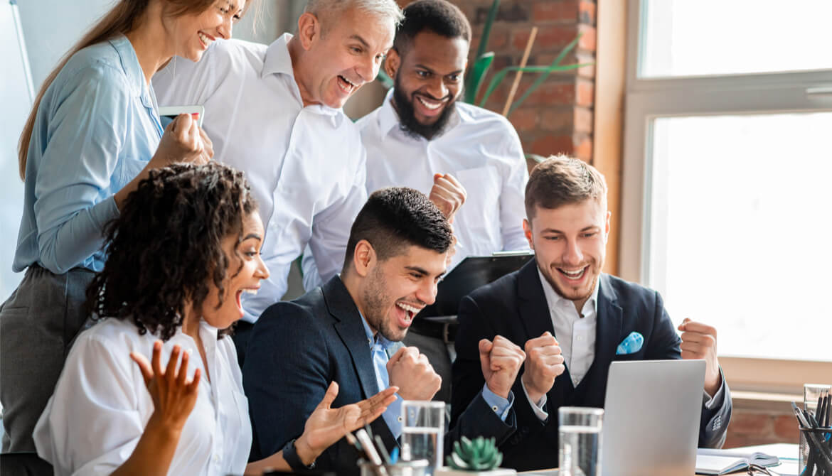 happy, diverse business people celebrating success with a laptop
