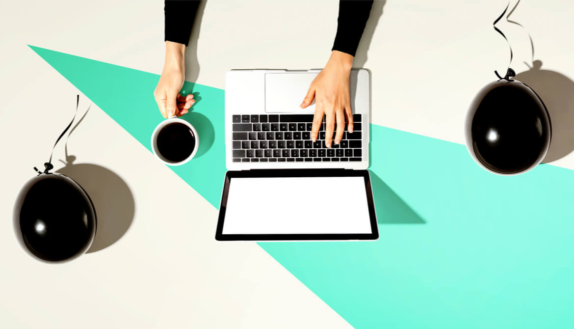 person using laptop with black balloons