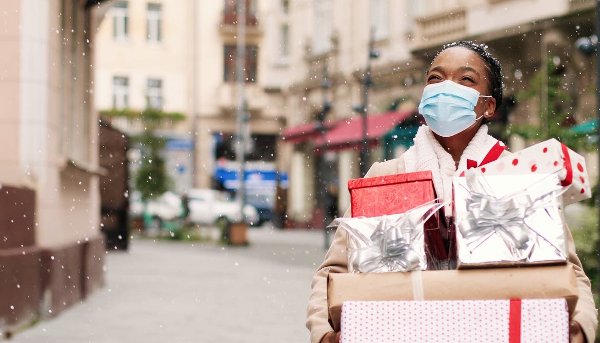 woman holiday shopping with packages and snow