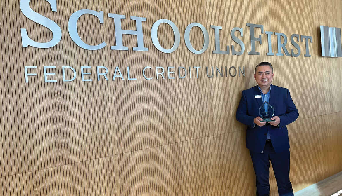 Alex Hsu of SchoolsFirst Federal Credit Union holding CUES Emerging Leader award