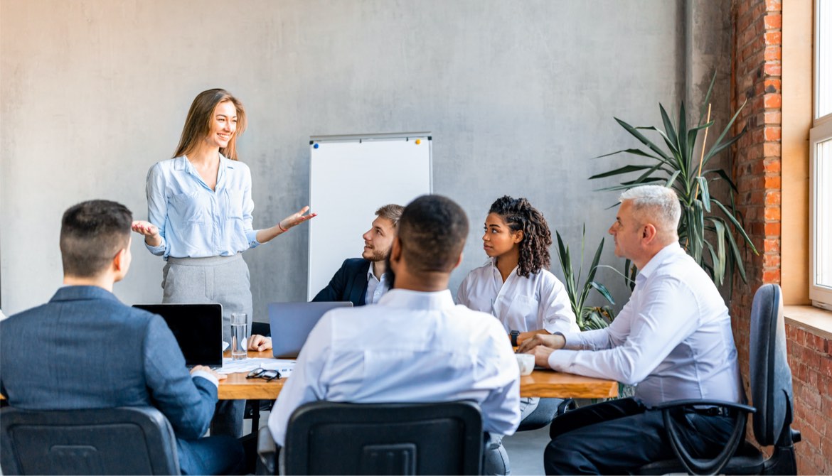 confident young businesswoman presenting to a diverse team at the office