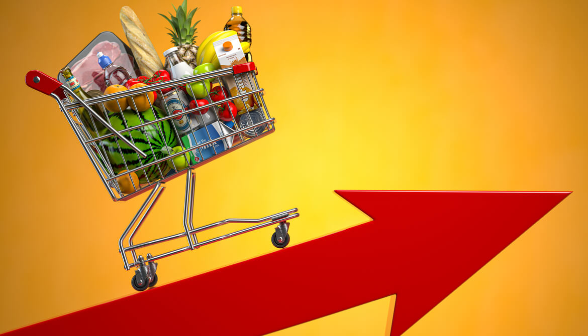 loaded grocery cart going up a red arrow signifying inflation