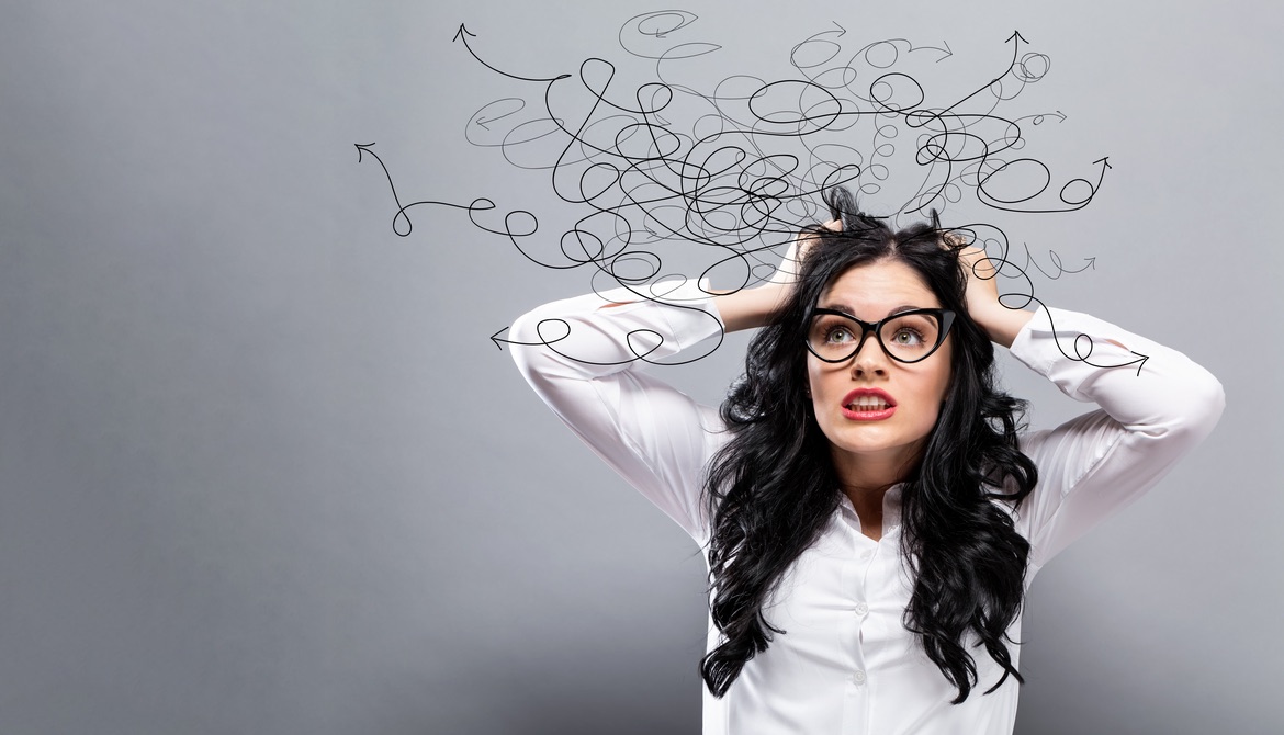 stressed young businesswoman wearing glasses pulls her hair while thinking about tangled mess of options