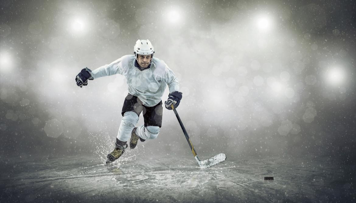 hockey player skates to the puck