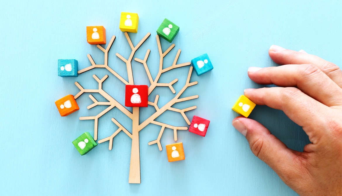 wooden tree with people icons over blue table