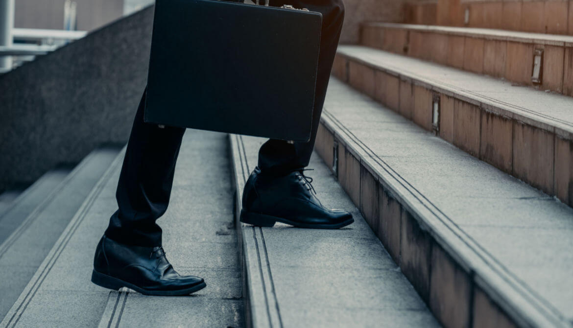 a businessman with a briefcase walks up stairs