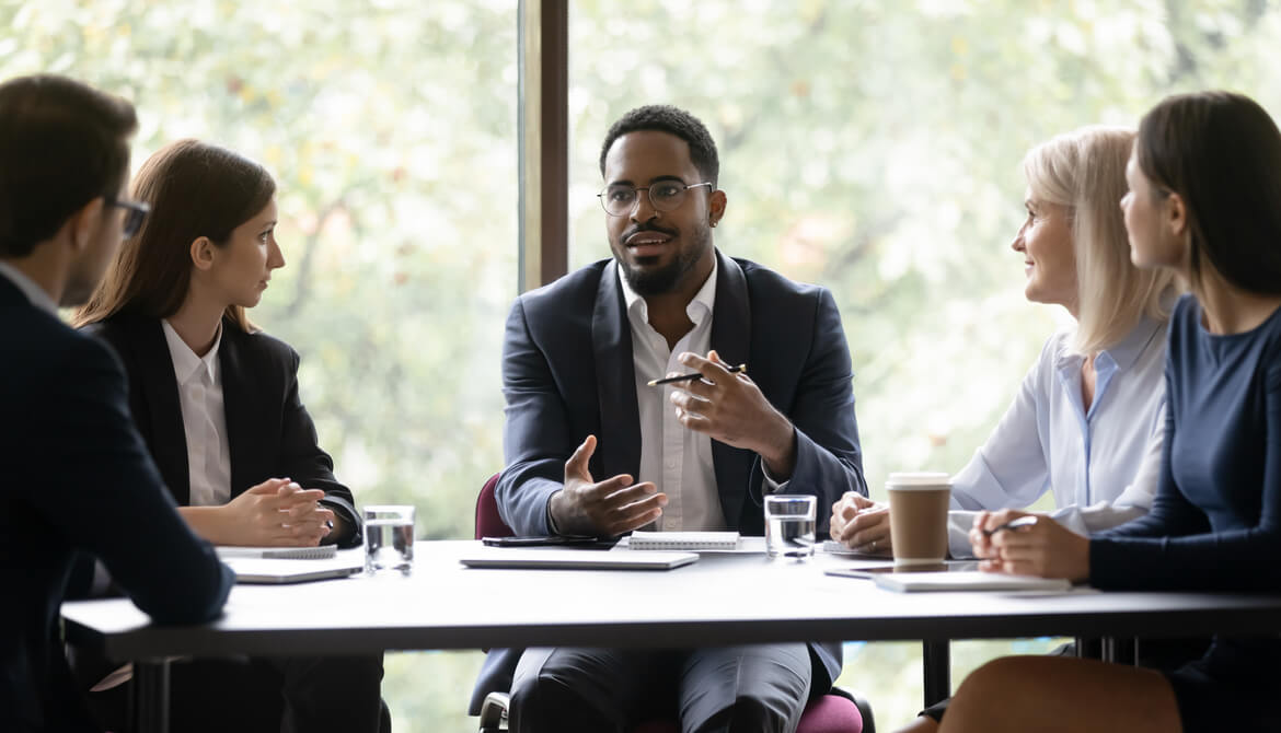 engaged Black business leader holding discussion with employee team