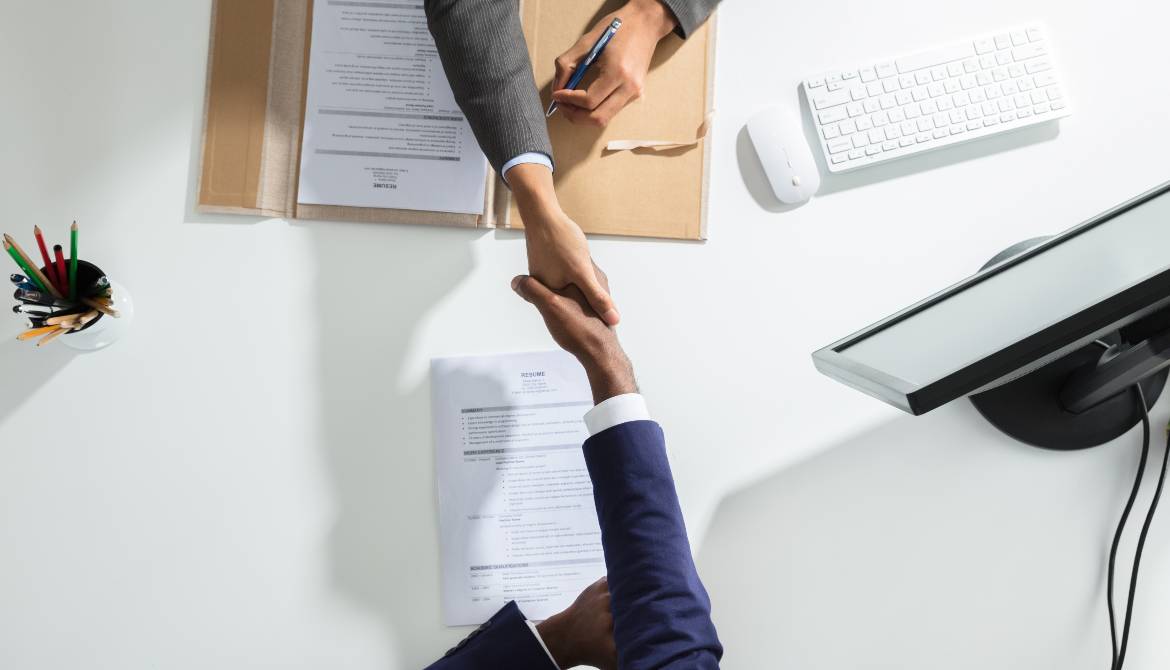 businessperson shaking hands over a table