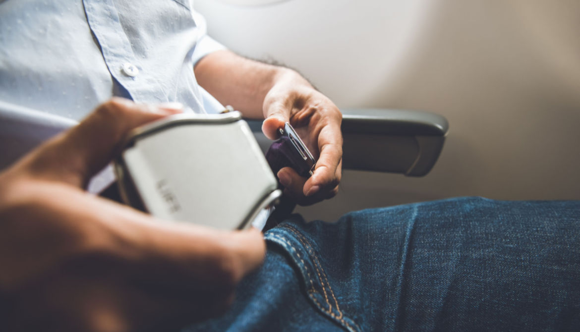 man fastens seat belt on airplane