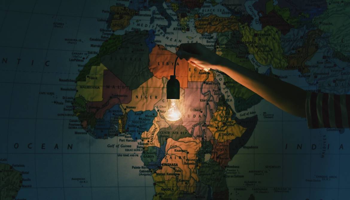 hand with light bulb in front of map of Africa