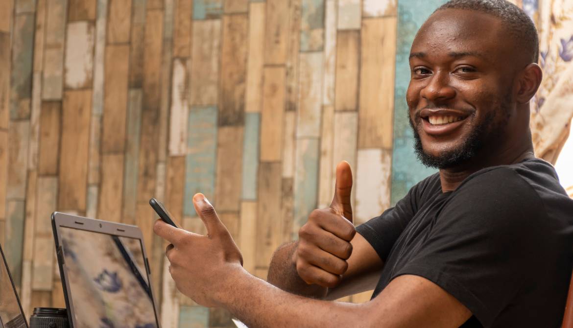 young black man working on his laptop with thumbs up