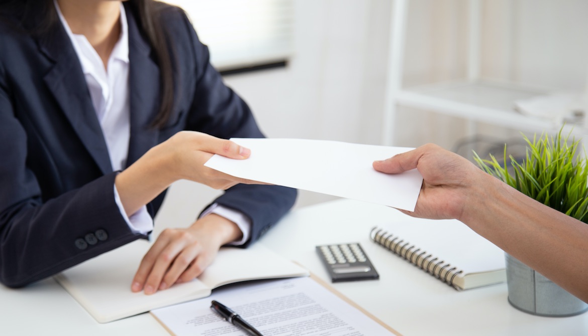 HR manager hands employee bonus check in envelope