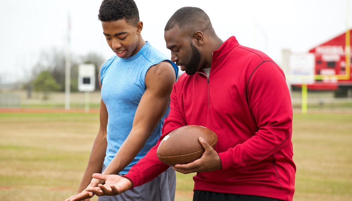 Football coach advising young athlete
