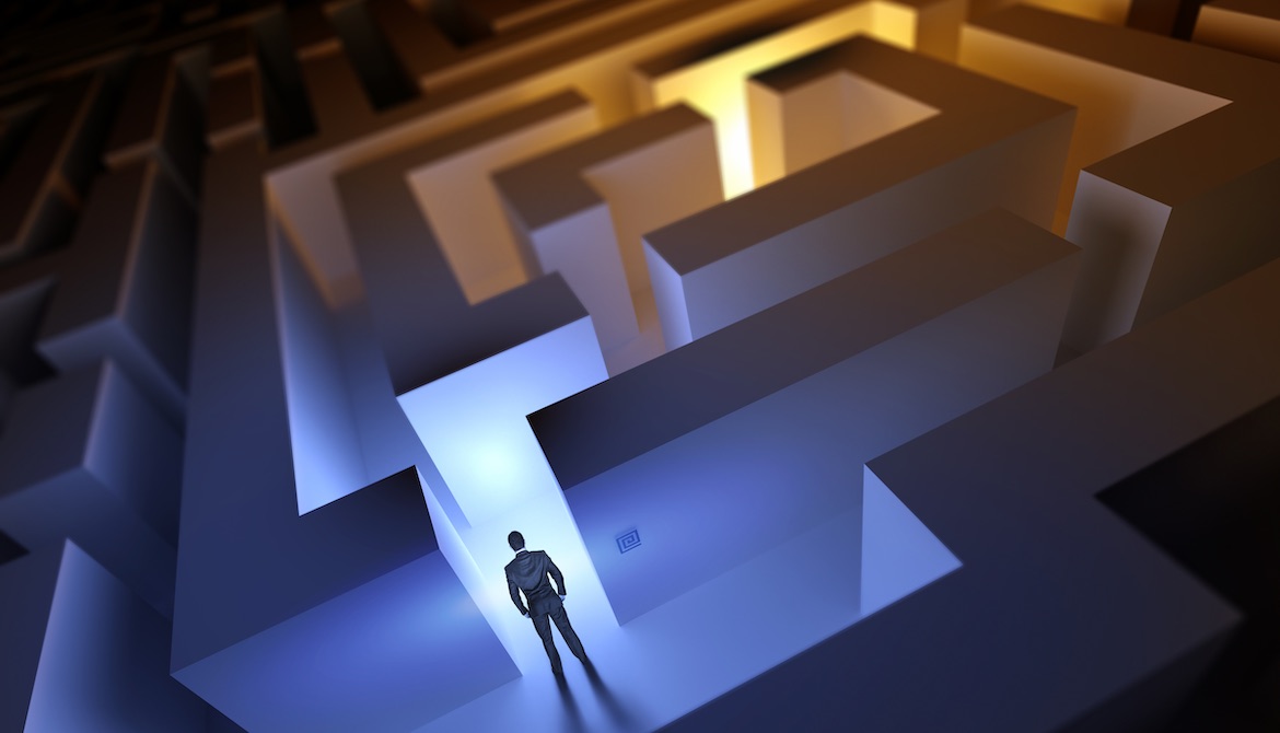 usinessman stands at entrance to maze with sections in both shadows and bright light