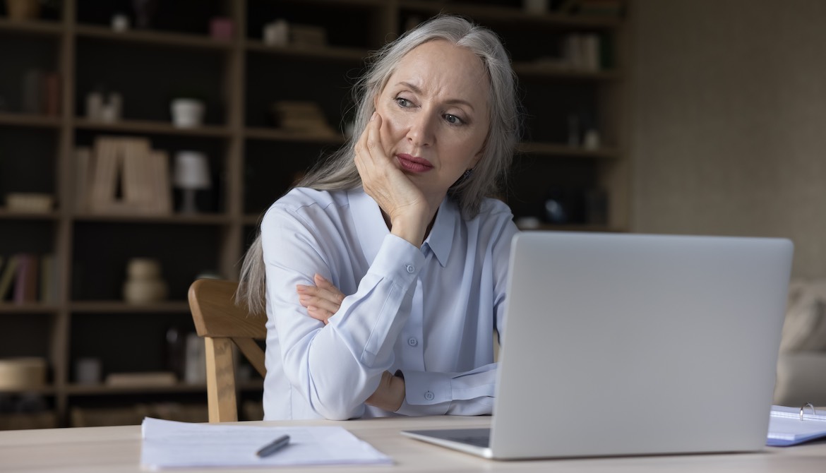 mature woman at desk with laptop