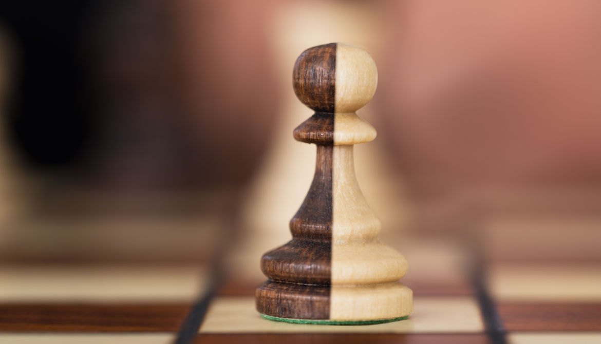 close up of a chess pawn split down the middle with black on one side and white on the other