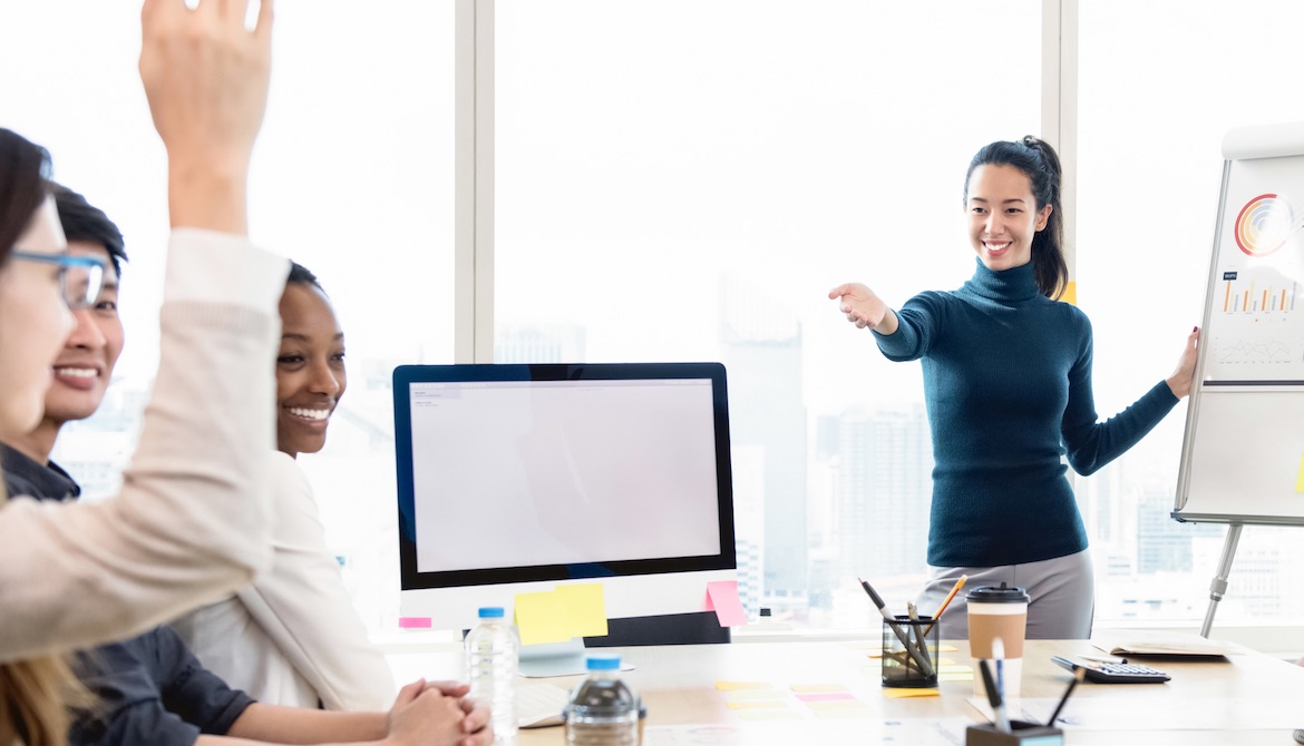 confident young businesswoman asks question to team during presentation