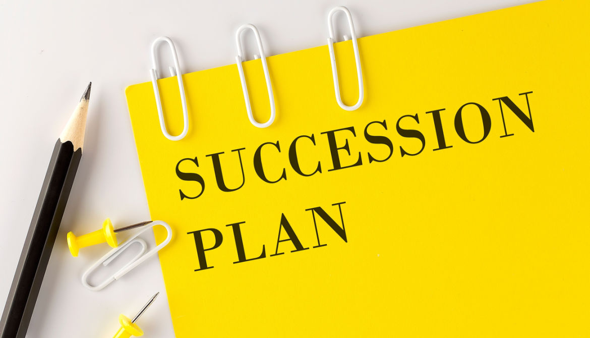 SUCCESSION PlAN word on the yellow paper with office tools on the white background