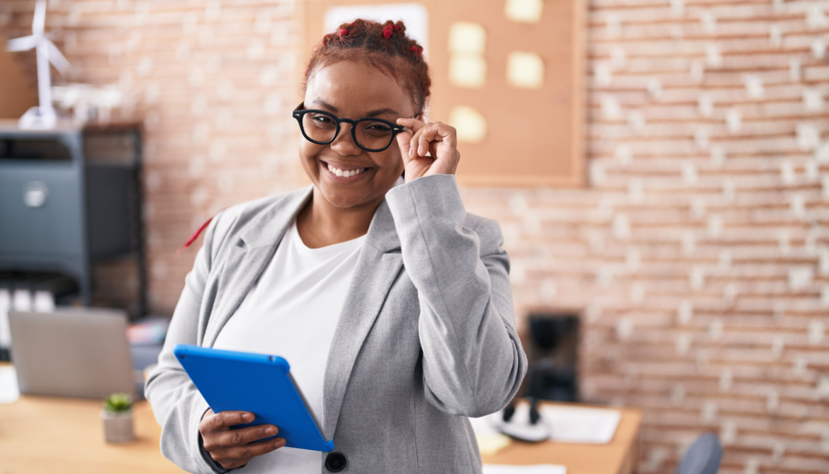 smiling African American woman puts on glasses