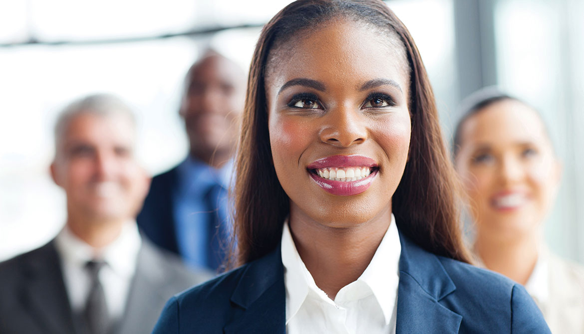 new board member smiling and standing in front of other directors