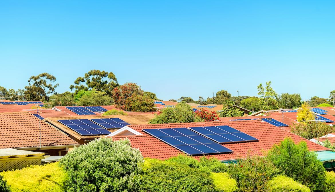 solar panels on roofs of neighborhood homes on sunny day