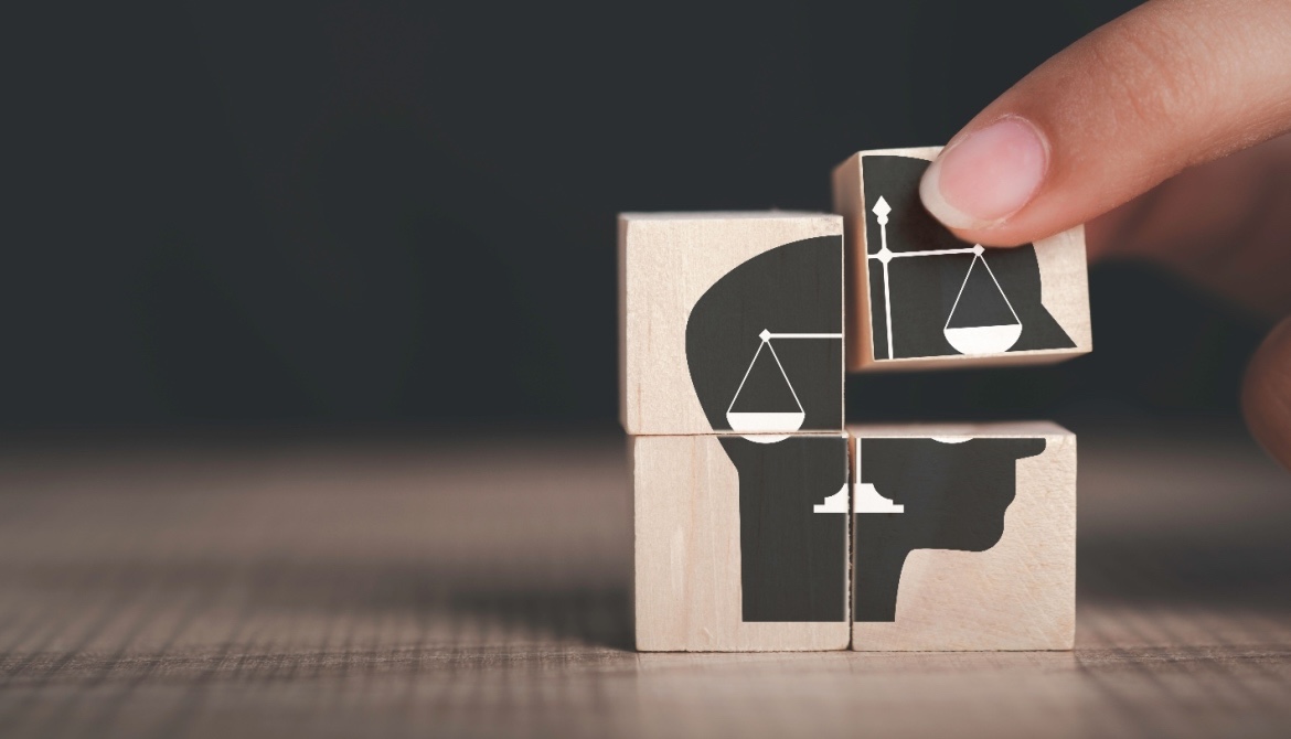 four small blocks that when placed together show an illustration of a human head and the scales law symbol