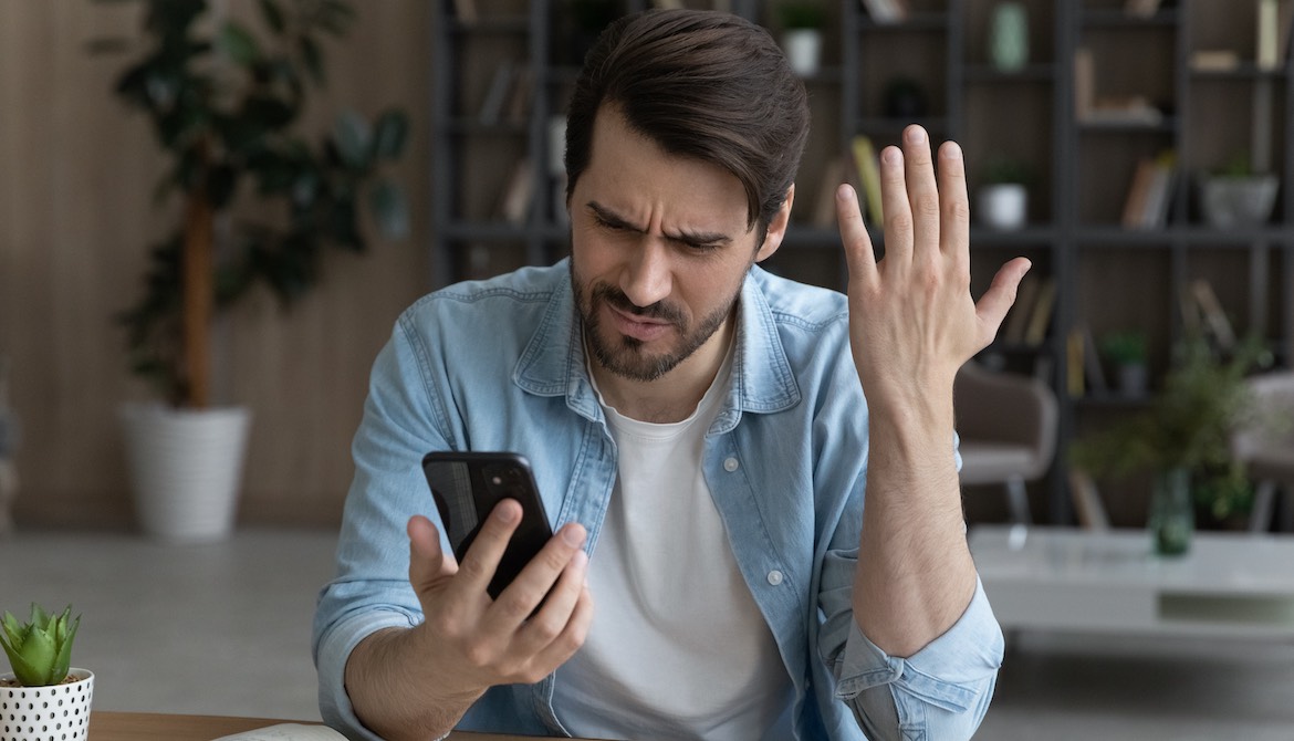 upset young man looking at phone