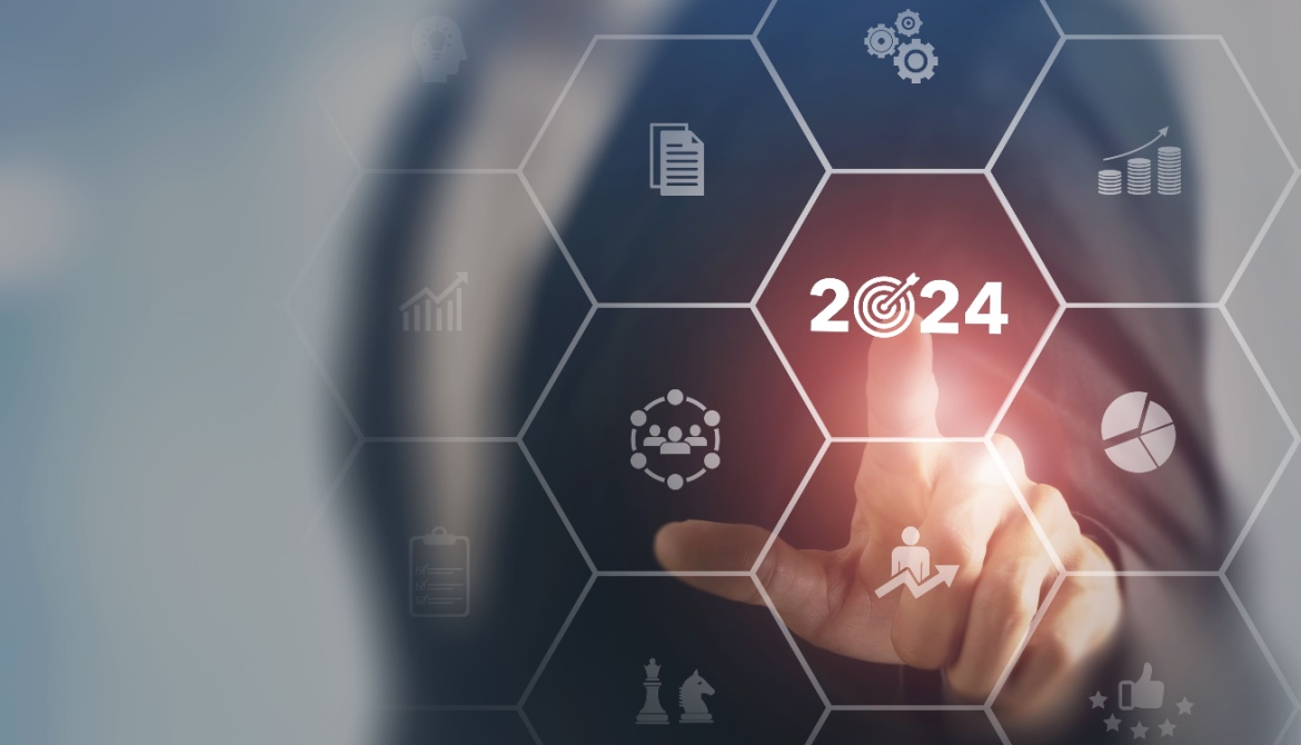 Businessman touching a 2024 business target icon with other icons floating on a screen around it