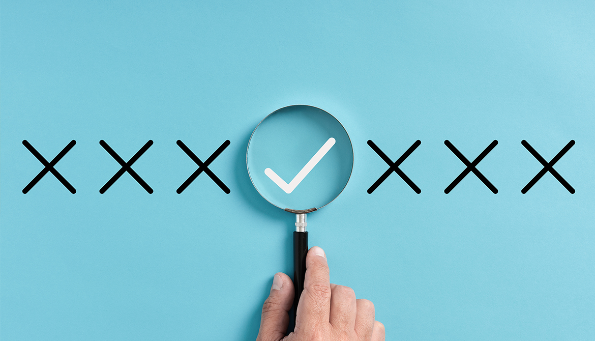 line of X's with a magnifying glass over the check mark