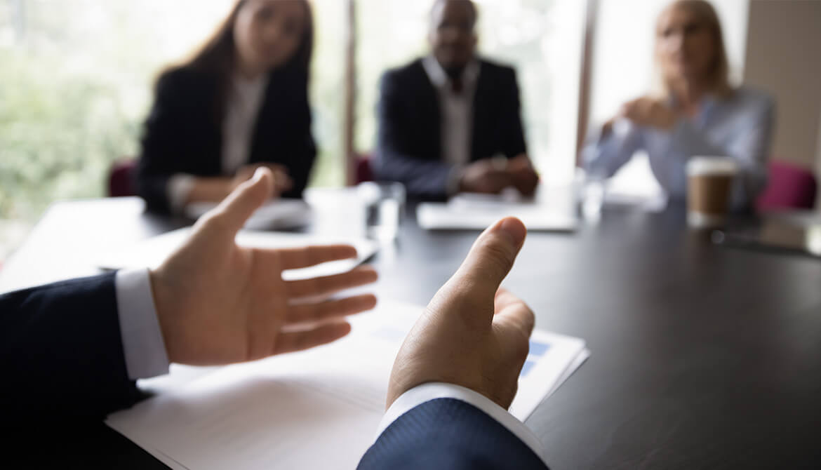 hands openly extended explaining around a board table