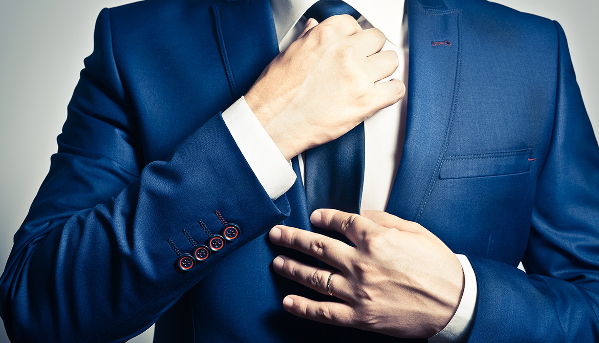 torso of male straightening his tie