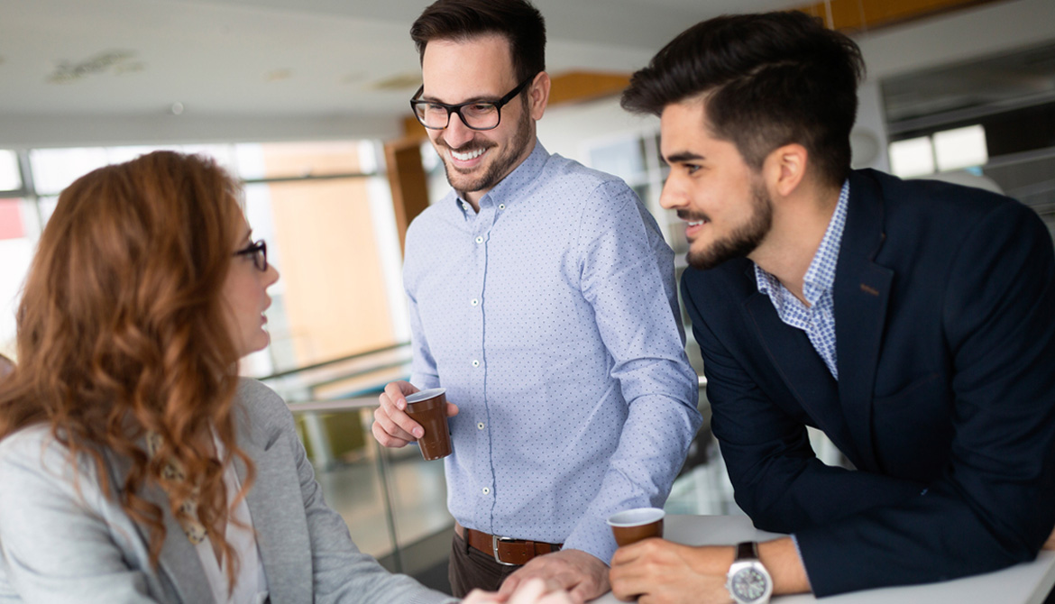 2 males speaking to a female