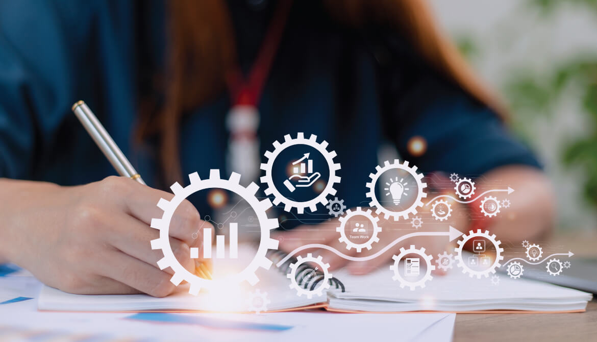 man writing in notebook with an overlay of gears with graphics inside of them