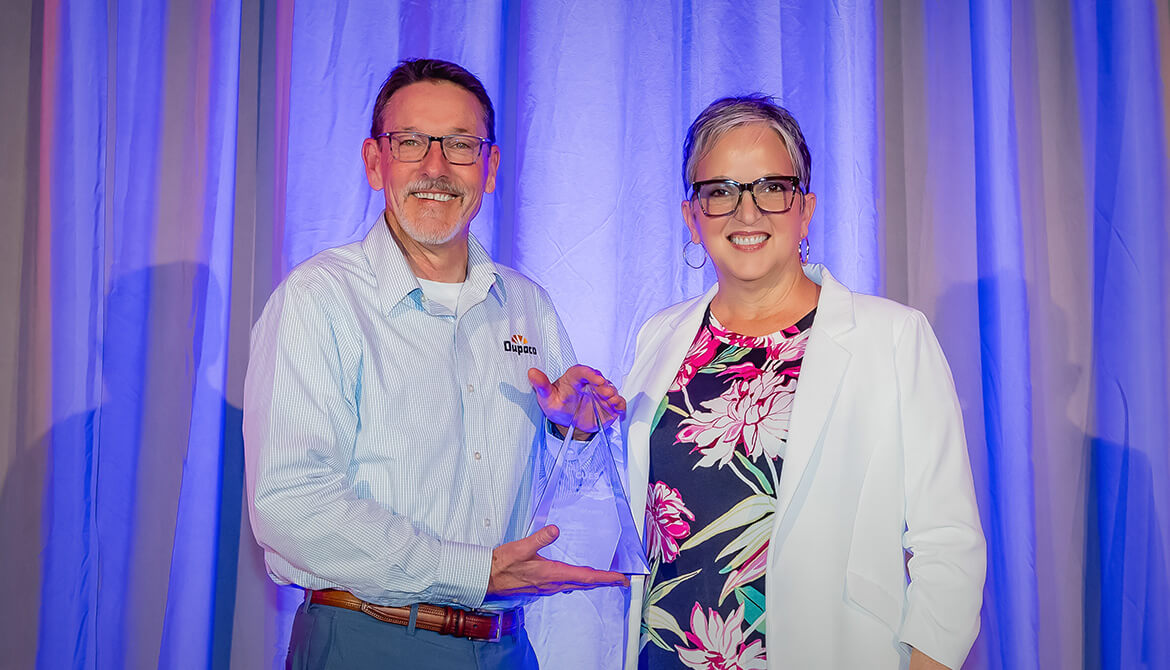 Joe Hearn accepting award from CUES CEO Heather McKissick
