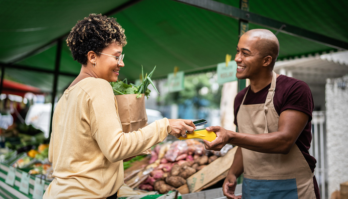 woman making a purchase at farmers market stand
