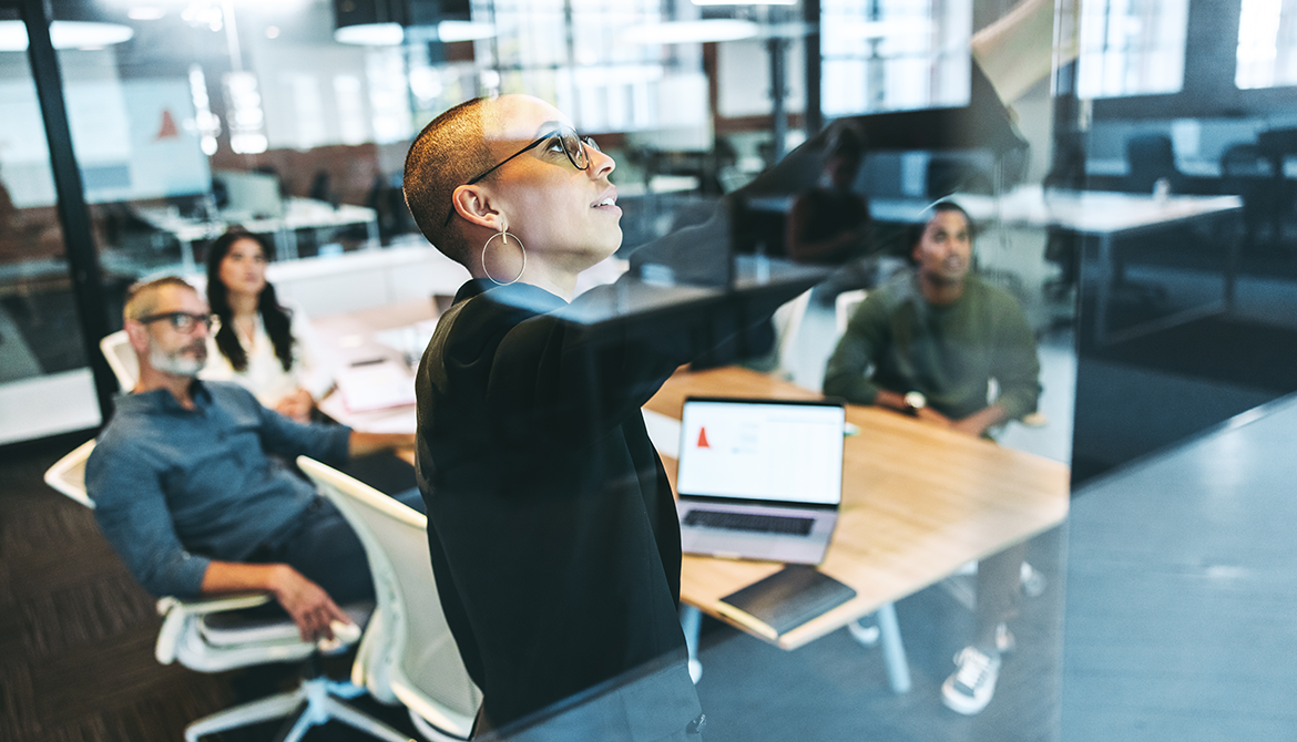 woman pointing at board in meeting